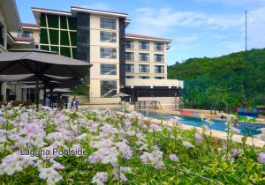 a hotel with a pool and flowers in the foreground at Fairways and Bluewater Boracay in Boracay