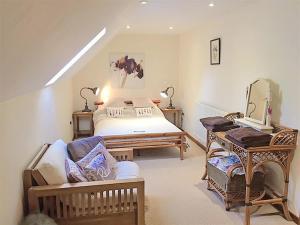 a bedroom with a bed and a tv and a couch at Upper Barn Cottage in Aberangell