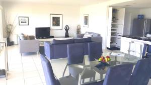 a living room with a blue couch and a glass table at Island Waterfront Getaway - WiFi in Hindmarsh Island