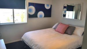a bedroom with a bed with two pillows on it at Island Waterfront Getaway - WiFi in Hindmarsh Island