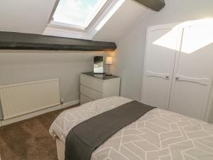 a bedroom with a bed and a skylight at Rose Cottage in Grange Over Sands
