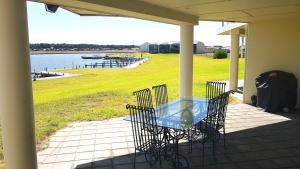 a table and chairs on a porch with a view of the water at Island Waterfront Getaway - WiFi in Hindmarsh Island