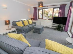 een woonkamer met banken en een flatscreen-tv bij Rose Cottage in Grange Over Sands