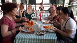 un gruppo di persone sedute a tavola che mangiano cibo di Jojies Homestay Fortkochi a Cochin