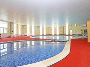 a large swimming pool in a building with a red carpet at 9 Manorcombe Bungalows in Callington