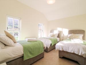 een slaapkamer met 2 bedden en een bank bij Katies Cottage in Newry