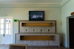 a living room with a tv on a wall at Hotel Palmas de La Serena in La Serena