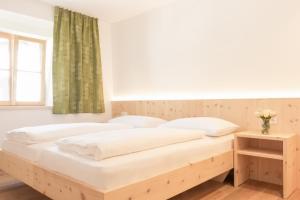 een slaapkamer met een houten bed en een raam bij Didi`s Appartments in Glorenza