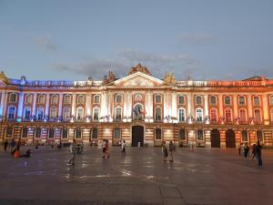 a large building with people walking in front of it at Hotel Wilson Square in Toulouse