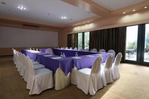 una sala conferenze con un lungo tavolo e sedie bianche di Technopark Hotel a Santa Rosa Altre 37 foto