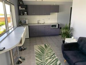 a kitchen and living room with a table and a couch at Mason lane Apartment in Whangarei