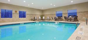 einen Pool in einem Hotelzimmer mit Stühlen und einem Tisch in der Unterkunft Holiday Inn Express Evansville - West, an IHG Hotel in Evansville