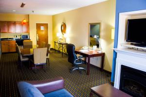 een woonkamer met een bank, een tafel en een open haard bij Holiday Inn Express Hotel & Suites Sanford, an IHG Hotel in Sanford