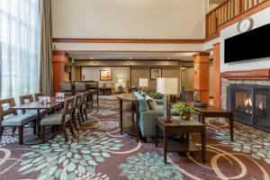 - un hall avec une cheminée, des tables et des chaises dans l'établissement Staybridge Suites Davenport, an IHG Hotel, à Bettendorf