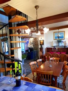 a dining room with a wooden table and chairs and a room with a dining table at La Valerienne in Saint-Valery-sur-Somme