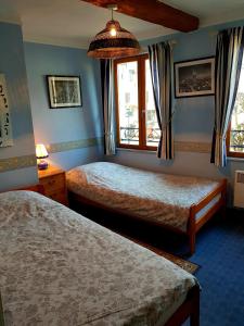 a hotel room with two beds and a window at La Valerienne in Saint-Valery-sur-Somme