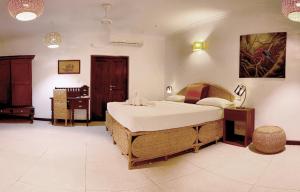 
a bedroom with a bed, a chair and a lamp at Dream Garden in Arugam Bay
