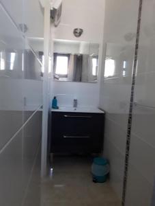ein Bad mit einem schwarzen Waschbecken und einem Spiegel in der Unterkunft Villa en bord de plage in Sète