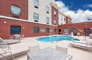 a patio with a swimming pool in front of a building at Holiday Inn Express & Suites Longview South I-20, an IHG Hotel in Longview