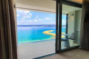 uma porta de vidro deslizante com vista para o oceano em Hotel Villa Margaret em Malinska