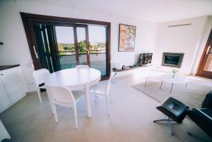 een witte eetkamer met een witte tafel en stoelen bij Amazing penthouse at La Fosca beach in Palamós