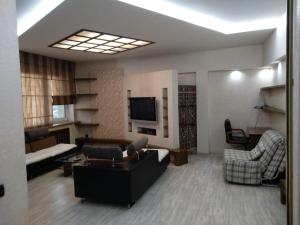 sala de estar con sofá y TV en D'Rami en Almaty