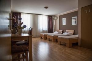 a hotel room with two beds and a table at Hostel Milkaza in Novi Sad