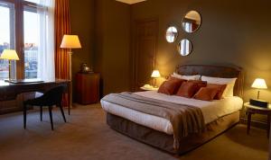 una camera con letto, scrivania e specchio di Hotel Carlton a Lille