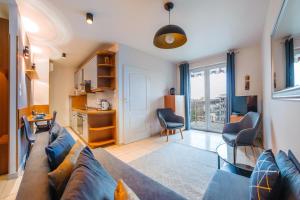 a living room with a couch and a table at Apartamenty Sun&Snow Reymonta in Kołobrzeg