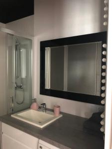 a bathroom with a sink and a large mirror at Apartament City Centre 108 in Olsztyn