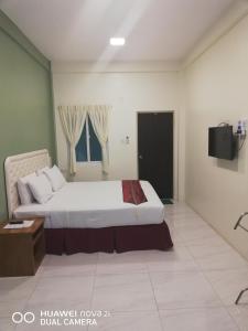 una camera da letto con un letto e una televisione di Supreme Hotel Yangon a Yangon