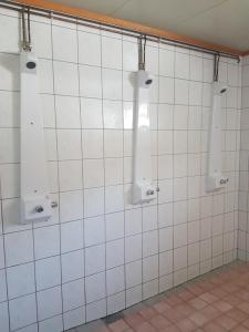 a bathroom with three lights on a white tiled wall at Jønndalen Høyfjellseter in Uvdal
