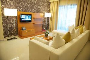 a living room with a white couch and a television at Grand Bellevue Hotel Apartment Dubai in Dubai