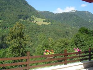 uma cerca de madeira com flores no topo de uma montanha em L'Horizon des Alpes em Le Petit-Bornand-lès-Glières