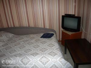 1 dormitorio con 1 cama y TV en una mesa en Viktoria Hotel, en Cherepovets