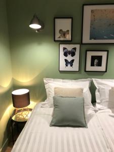 een slaapkamer met een wit bed en een groene muur bij Les Petits Apparts Versailles in Versailles