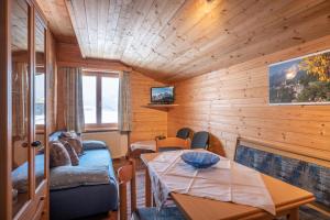 Pokój ze stołem i kanapą oraz pokój z drewnianymi ścianami w obiekcie Moser w mieście Sankt Johann in Tirol