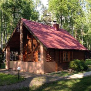 una pequeña casa de madera con techo rojo en Zakatek Kliczkow, en Osiecznica