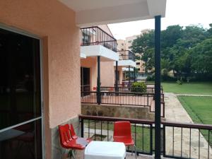 a balcony with two red chairs and a building at Makwetu Villas in Mombasa