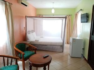 a small room with a bed and a table and chairs at Makwetu Villas in Mombasa