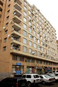 ein großes Gebäude mit davor geparkt in der Unterkunft 3 Bedroom Apartment in Homey Residence in Yerevan