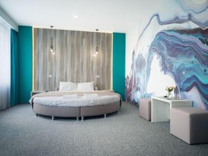 sypialnia z łóżkiem i obrazem na ścianie w obiekcie Art Hotel Palma w Lwowie