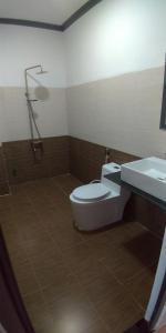 y baño con aseo, lavabo y ducha. en Khách sạn Ánh Đông, en Phan Rang