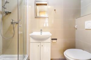 La salle de bains est pourvue de toilettes, d'un lavabo et d'une douche. dans l'établissement Cozy Local Naplavka Apartments in Center, à Prague