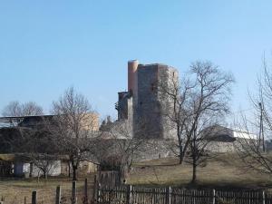 un antico castello dietro una recinzione di legno di Bari Tanya a Kisnána