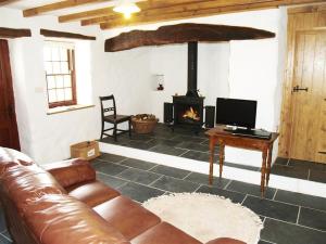 a living room with a couch and a fireplace at Panteurig Cottage in Goodwick
