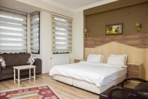 a bedroom with a large white bed and a couch at Sheriff Royal Suite in Istanbul