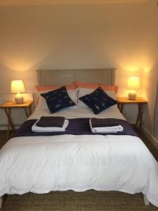 a large bed with two lamps on two tables at Three Chimneys Farm Accommodation in Goudhurst