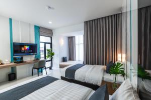 um quarto de hotel com duas camas e uma televisão em The Hi Place em Roi Et