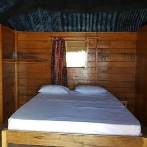 a bed in a wooden room with a window at Cap Marniane in Mar Lodj